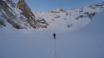 Men cross-country skiing and climbing in the mountains.