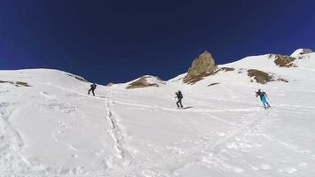 Men cross-country skiing and climbing in the mountains.