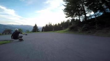 um skatista em uma corrida de skate em declive em uma estrada de montanha. video