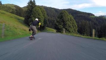 un skateur en descente sur une route de montagne.