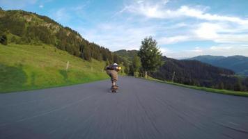 un skateur en descente sur une route de montagne.