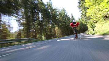 um skatista em uma corrida de skate em declive em uma estrada de montanha. video