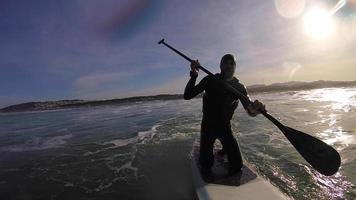 pov de um homem de joelhos em um sup stand up paddleboard. video