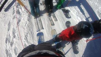 POV of snowboarders on a ski lift at a ski resort.