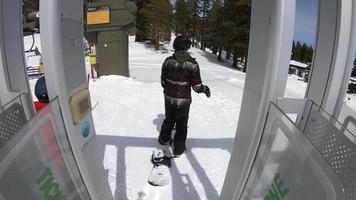 POV of snowboarders on a ski lift at a ski resort.