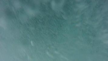 Underwater view of turbulent waves breaking at the beach.