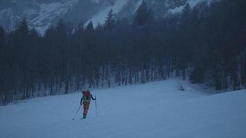Ein Skifahrer fährt im Schnee einen Berg hinauf. video