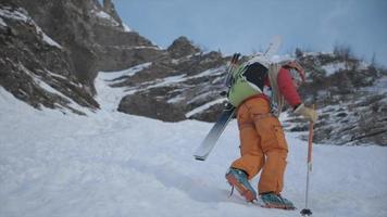 ein Bergsteiger klettert mit Steigeisen im Schnee hoch. video