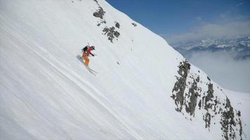 uno sciatore che scia su una ripida montagna nella neve.