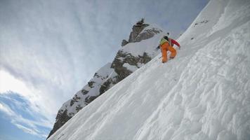 un alpinista che si arrampica con i ramponi nella neve. video
