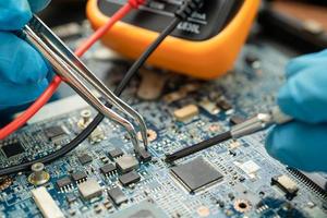 technician repairing inside of hard disk by soldering iron. Integrated Circuit. the concept of data, hardware, technician and technology. photo