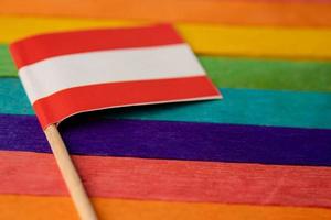 Asutria flag on rainbow background flag symbol of LGBT gay pride month  social movement rainbow flag is a symbol of lesbian, gay, bisexual, transgender, human rights, tolerance and peace. photo