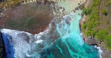 vista aérea do drone de um recife de coral e ondas na praia.