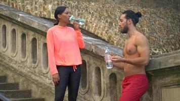 Ein Paar macht nach dem Training eine Pause, um Wasser zu trinken.