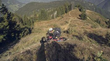 Mountain biker biking downhill on a rocky trail in the mountains.