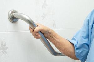 Asian senior or elderly old lady woman patient use toilet bathroom handle security in nursing hospital ward, healthy strong medical concept. photo