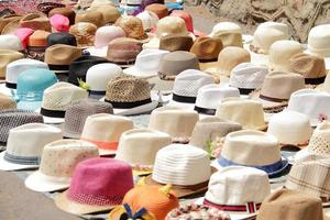 Montón de sombreros diferentes en el mercado de la calle. foto