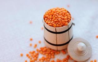 red raw lentils in wooden bowl place for text