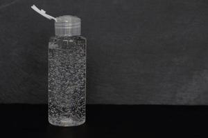 bottle of soap, shampoo, shower gel, antiseptic,disinfectant or other sanitizer on black stone texture background, copy space photo