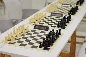 set of chess on a board, ready for competition, white and black set, king, queen, horse figures photo