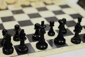 set of chess on a board, ready for competition, white and black set, king, queen, horse figures photo