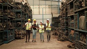 A group of people in safety uniforms and helmets in warehouse- Workers of various races such as Caucasian, Black, and Asian are factory employees and colleagues walking and talking in factory. video