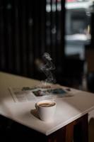 White coffee mug on the table inside the cafe photo