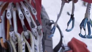 close-up de mosquetões em um cinto de arnês de escalada em um alpinista nas montanhas.