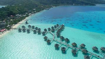 Vista aérea de un dron de un resort de lujo y bungalows sobre el agua en la isla tropical de Bora Bora. video