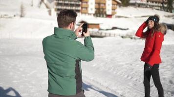 A man takes photographs of his wife, lifestyle in the snow at a ski resort. video