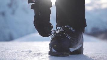 una donna con scarponi da sci che si prepara ad andare a sciare sulla neve in una stazione sciistica.