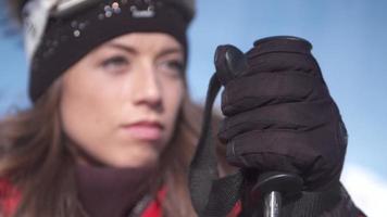 una donna con guanto e bastoncino da sci che si prepara ad andare a sciare sulla neve in una stazione sciistica. video