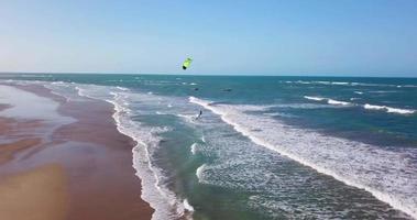 vista aerea del drone di un uomo che fa kitesurf su una tavola da aquilone. video