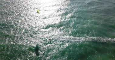 vista aerea del drone di un uomo che fa kitesurf su una tavola da aquilone. video