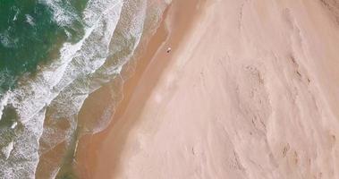 vista aerea del drone di un veicolo per auto jeep 4x4 che guida durante il viaggio di surf sulla spiaggia. video