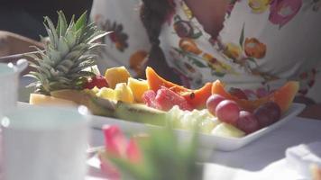 uma mulher come frutas frescas em um resort em uma ilha tropical.