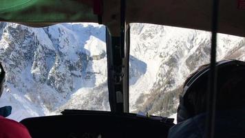 pov de una vista de helicóptero por la ventana, esquiando en las montañas. video