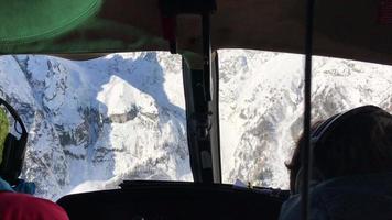 pov de una vista de helicóptero por la ventana, esquiando en las montañas. video