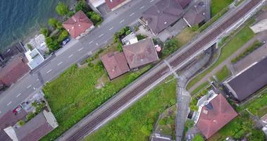 Luftdrohnenansicht einer Stadt mit Bahngleisen in der Nähe des Lago Maggiore, Schweiz. video