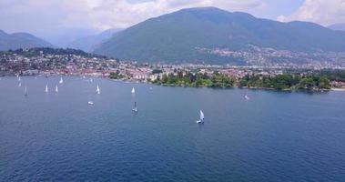 Luftdrohnenansicht von Segelbooten, die auf dem Lago Maggiore, Schweiz segeln. video