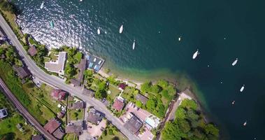 vista aérea de drone de una ciudad con vías de tren cerca del lago maggiore, suiza. video