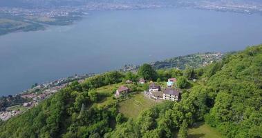 vista aerea del drone delle verdi colline sopra il lago maggiore, svizzera. video