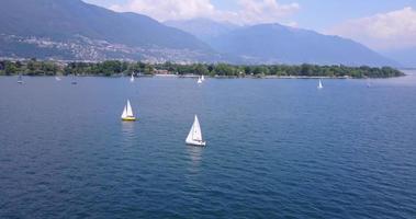 Aerial drone view of sailboats sailing on Lake Maggiore, Switzerland.