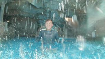 um menino brinca em uma caverna de piscina gruta azul em um hotel resort.