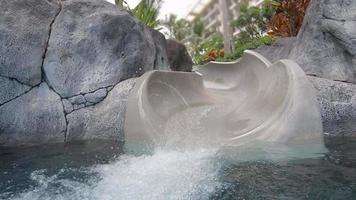 um toboágua em uma piscina em um resort de hotel. video