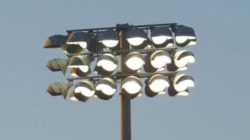 Stadion-Flutlichtbeleuchtung über Sportplatz bei einem Nachtfußballspiel, Freitagsnachtlichter, American Football.