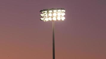 Stadion-Flutlichtbeleuchtung über Sportplatz bei einem Nachtfußballspiel, Freitagsnachtlichter, American Football.