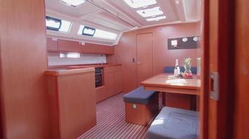 Interior view of a sailboat galley kitchen dining room table on a boat.