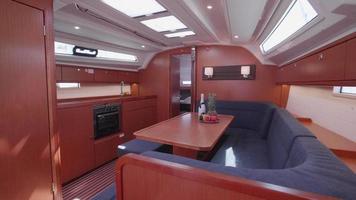 Interior view of a sailboat galley kitchen dining room table on a boat.