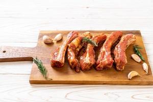 Costillas de cerdo crudas frescas listas para asar con ingredientes foto